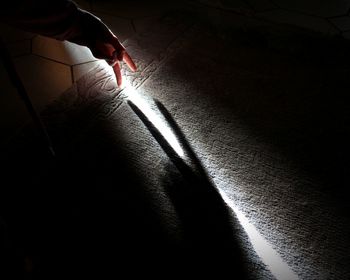 Midsection of woman with shadow on floor