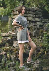 Full length portrait of woman standing on rock