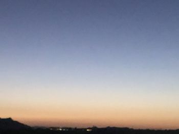 Silhouette landscape against clear sky at sunset