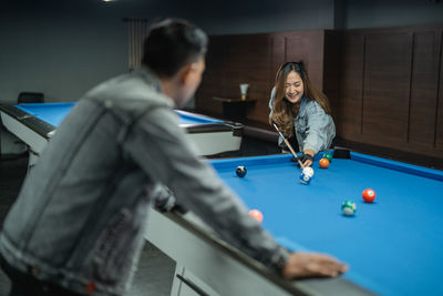 Midsection of woman playing pool