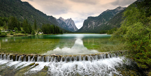 Scenic view of lake by mountains against sky