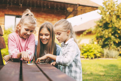 Friends have fun and play a wooden board game with colored chips in blue, red, green