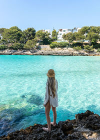 Rear view of woman looking at sea against clear sky