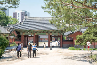 Tourists walking at changdeokgung palace during sunny day