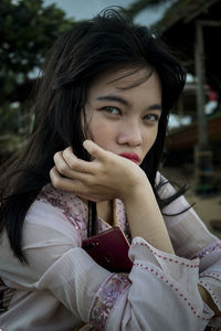 Portrait of young woman sitting outdoors