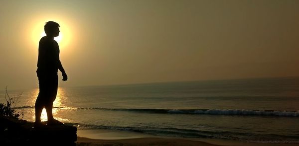 Silhouette of woman on beach at sunset