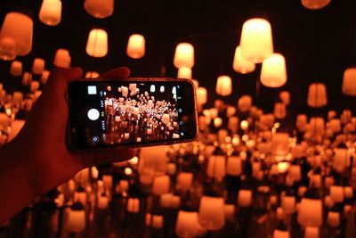 Close-up of hand using mobile phone at night