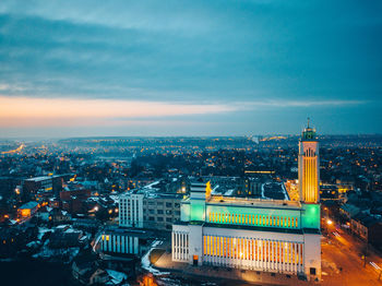 Illuminated cityscape against sky during sunset