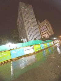 Reflection of illuminated buildings in swimming pool at night