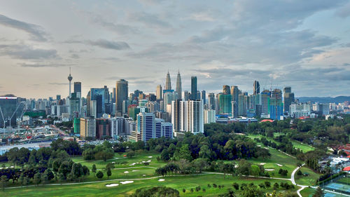 View of buildings in city against cloudy sky