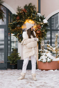 Portrait of woman standing by christmas tree