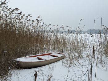 Boat moored in lake against clear sky