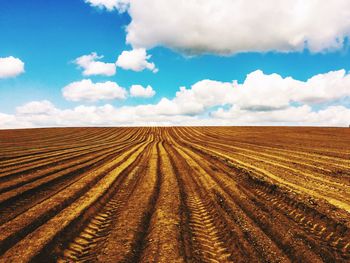 Scenic view of field against cloudy sky