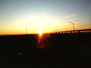 Silhouette railroad tracks against sky during sunset