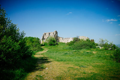 Built structure on landscape against blue sky