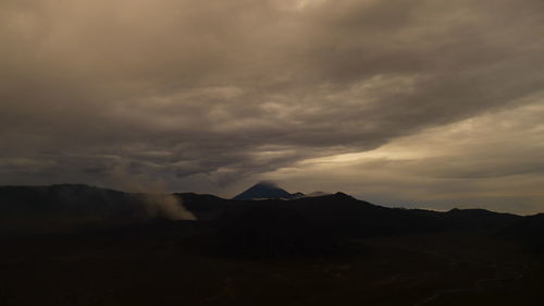 Scenic view of mountains against cloudy sky