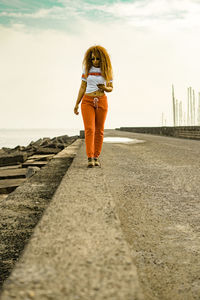 Woman standing in sea against sky