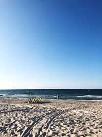 Scenic view of beach against clear blue sky