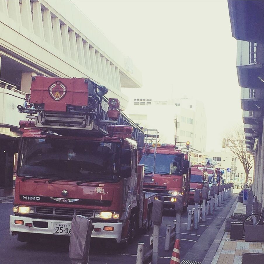 transportation, mode of transport, architecture, land vehicle, built structure, car, building exterior, clear sky, city, street, incidental people, city life, road, travel, day, stationary, public transportation, outdoors, building, copy space