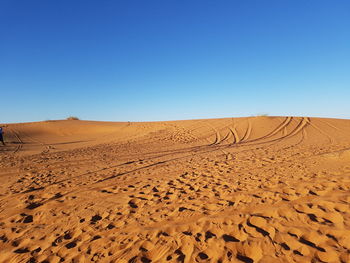 Scenic view of desert against clear blue sky