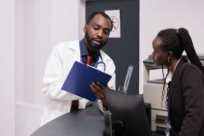 Portrait of doctor examining patient in clinic