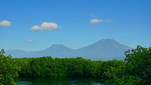 Scenic view of lake and mountains against blue sky