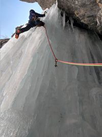 Low angle view of man climbing on ice