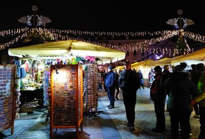 People in illuminated market at night