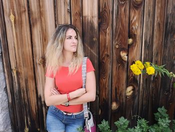 Full length of beautiful woman standing against red wall