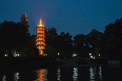 Illuminated temple building against sky at night