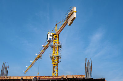 Low angle view of crane against sky