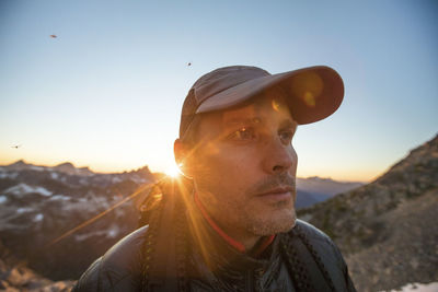 Portrait of backpacker wearing hat on mountain ridge.