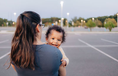 Mother with cute smiling son standing outdoors