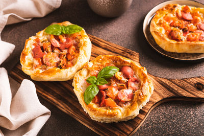 Chicago pizza pot pie with tomatoes, cheese and sausage on a wooden board