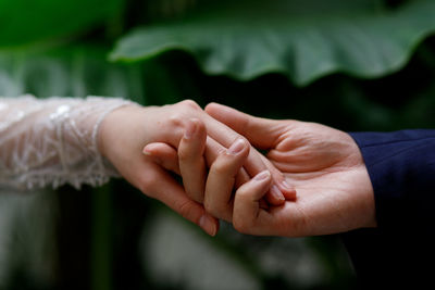 Cropped image of couple holding hands