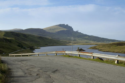 Scenic view of road by mountains against sky