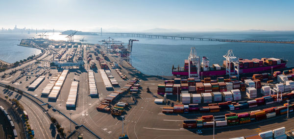 The oakland outer harbor aerial view. loaded trucks moving by container cranes.