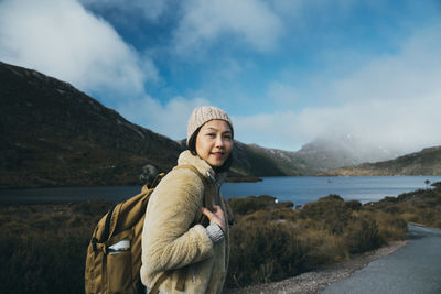 Portrait of woman standing against lake