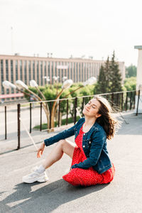 Young woman sitting in city