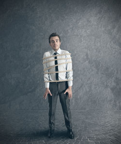 Portrait of young man standing against white background