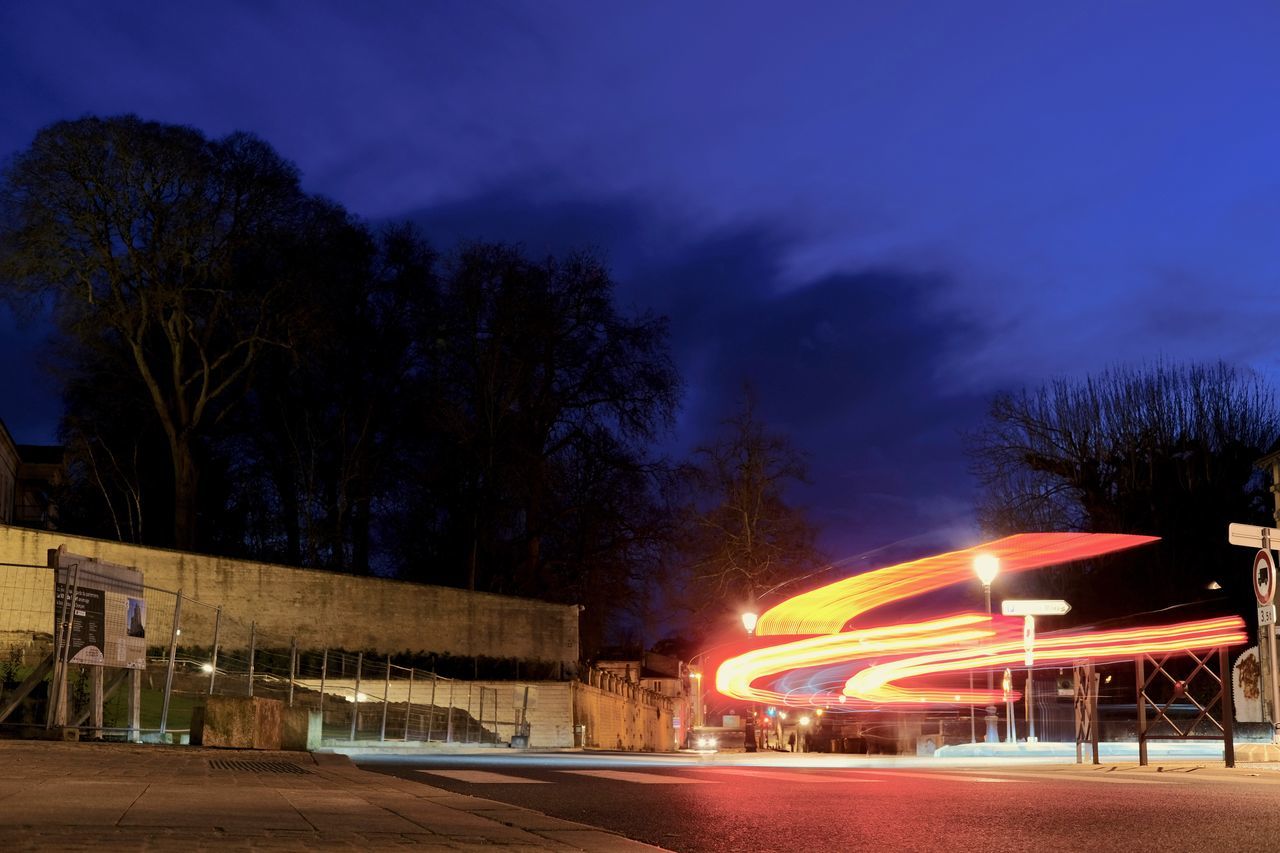 LIGHT TRAILS ON STREET AT NIGHT