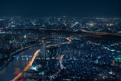 Aerial view of illuminated cityscape against sky at night