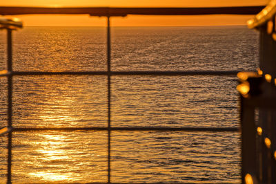Close-up of boat sailing on sea against sky during sunset