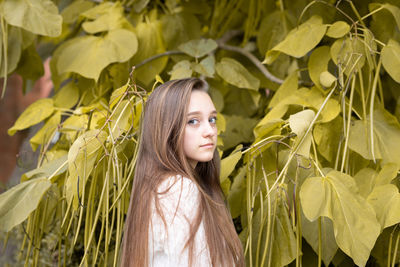 Portrait of woman standing by plants