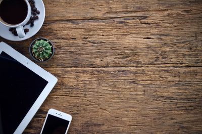 Directly above view of technology by houseplant and coffee on table