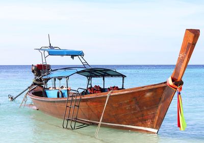 Ship moored on beach against sky