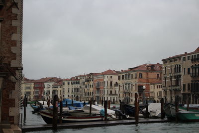 Canal amidst buildings in city against sky