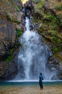 Man looking at waterfall