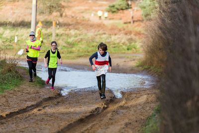 Rear view of people running on landscape