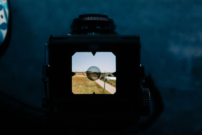 Road by landscape seen on camera screen